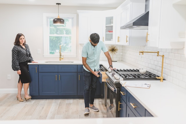 A real estate agent and potential homebuyer inside of a modern kitchen