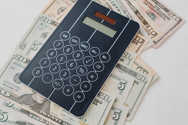 calculator laying on top of a bunch of cash
