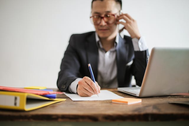 property manager writing something down while talking on the phone